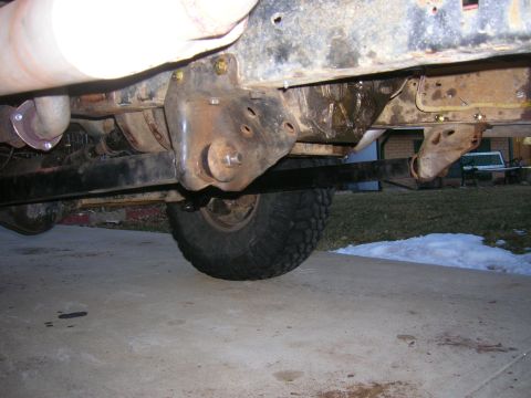1979 Ford Bronco - Close-up of vehicle undercarriage showing frame and suspension components, with a tire visible.
