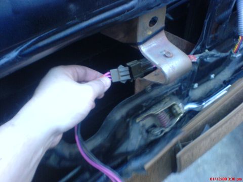 1986 Ford Bronco - A hand is shown connecting a wiring harness connector inside a vehicle's interior.