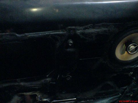 1986 Ford Bronco - Close-up of a car's interior door panel, showing a speaker and mounting hardware.