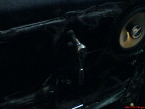 1986 Ford Bronco - Close-up of a car's interior door panel, showing a speaker and a tool.