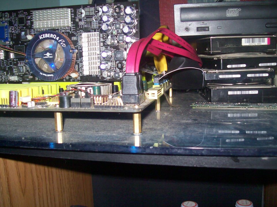 Computer motherboard with ICEBERQ 4 Pro cooler, SATA cables, and stacked hard drives