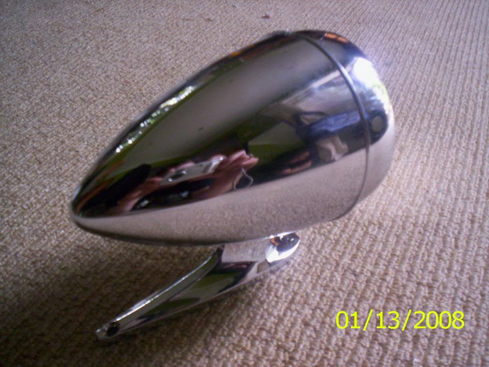 Chrome headlight with a bullet shape and a mounting bracket