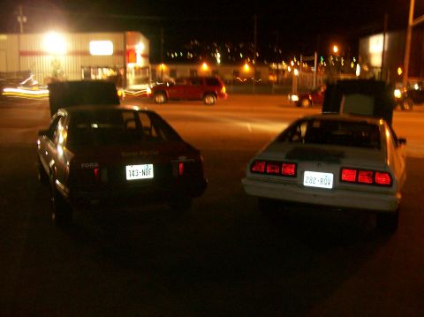 1978 Ford Mustang II - Two cars are parked side-by-side at night, with their hoods open.