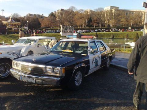 1991 Ford Crown Victoria - This 1991 Ford Crown Victoria police car is seen in a 3/4 front view, parked next to another vehicle.