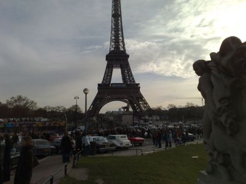 1991 Ford Crown Victoria - A view of the Eiffel Tower with a crowd and numerous vehicles gathered below.
