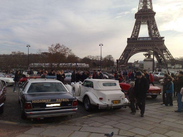 1991 Ford Crown Victoria police car, rear view, dark blue with 'HIGHWAY PATROL' text, parked near Eiffel Tower