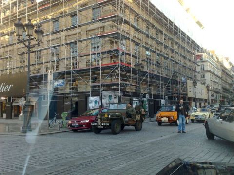 1991 Ford Crown Victoria - A street scene with multiple vehicles, including a jeep and several cars, in front of a building undergoing renovation.