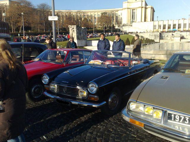 Black classic convertible at a car show with people nearby