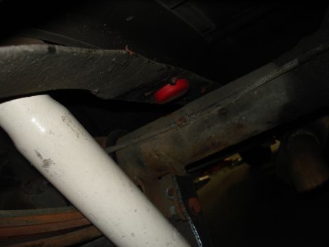 1979 Chevrolet C/K Pickup - A close-up view of the undercarriage of a vehicle, focusing on suspension parts and a red component.