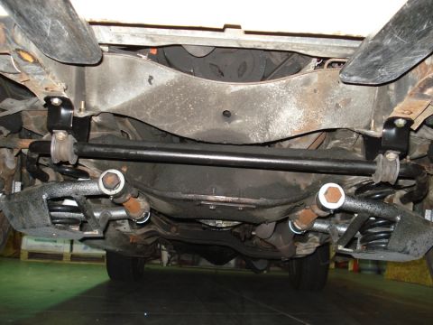 1979 Chevrolet C/K Pickup - The underside of a vehicle shows its suspension components, including the sway bar and springs.
