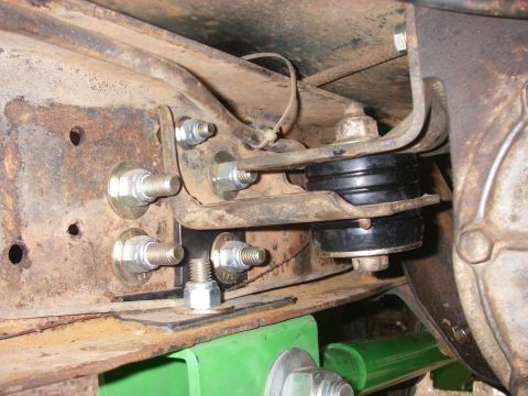 1978 Ford Bronco - A close-up view of a vehicle's frame shows modifications to the body mounts with new hardware.