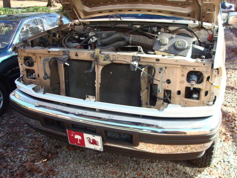 1992 Ford Bronco - The engine bay of a 1992 Ford Bronco is visible with the hood raised, showing the engine and front grille.