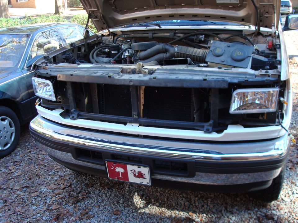 1992 Ford Bronco engine bay with hood open, parked next to another car