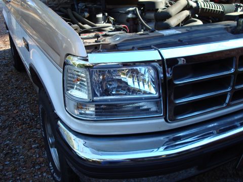 1992 Ford Bronco - Close-up of a 1992 Ford Bronco's front end, showing the grille and headlight.