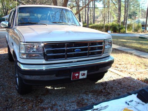 1992 Ford Bronco - This Ford F-150 pickup truck features a distinctive chrome grille and a blue oval Ford emblem.