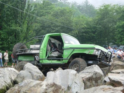 1978 Ford Bronco - This modified truck navigates a rocky obstacle course with spectators watching.