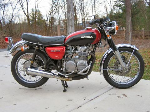 1985 Ford LTD Crown Victoria - A red and black Honda 500 Four motorcycle is parked on a concrete surface with trees in the background.