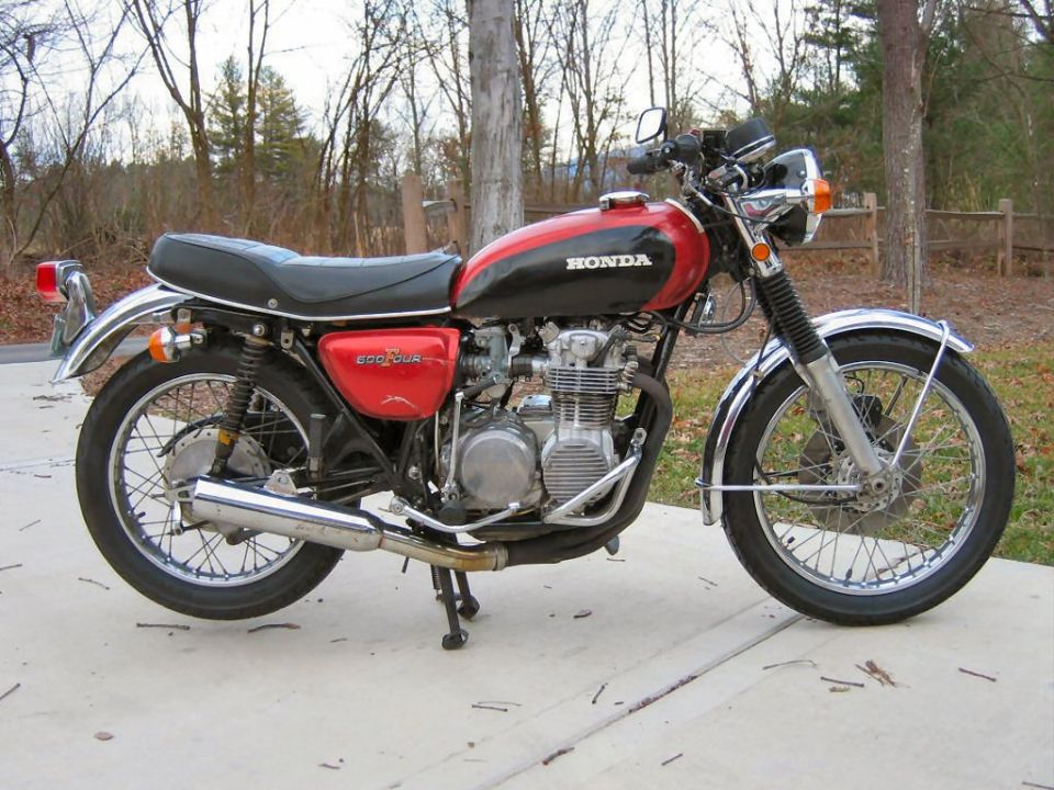 Red and black Honda motorcycle side view. Text on tank reads HONDA, text on side cover reads 500 FOUR