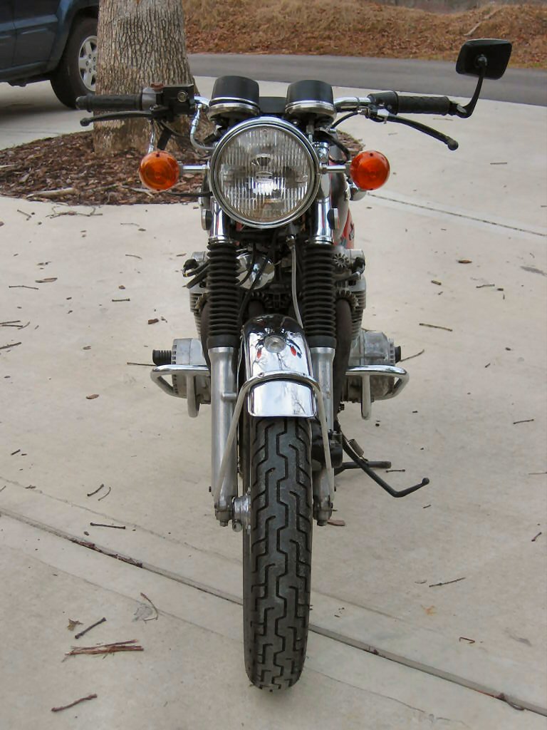 Front view of a motorcycle with chrome fenders, orange turn signals, and a round headlight