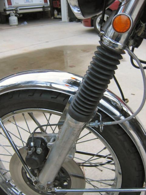 1985 Ford LTD Crown Victoria - Close-up of a motorcycle's front suspension and wheel assembly.