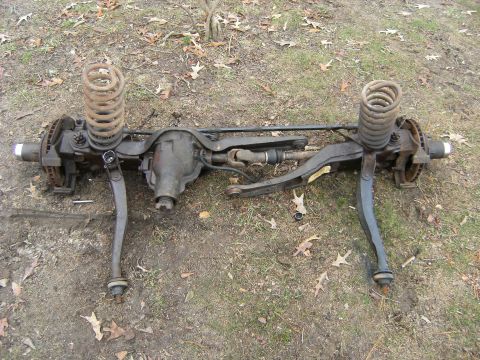 1992 Ford F-150 - Complete front axle assembly removed from a vehicle, showing springs and brake components.