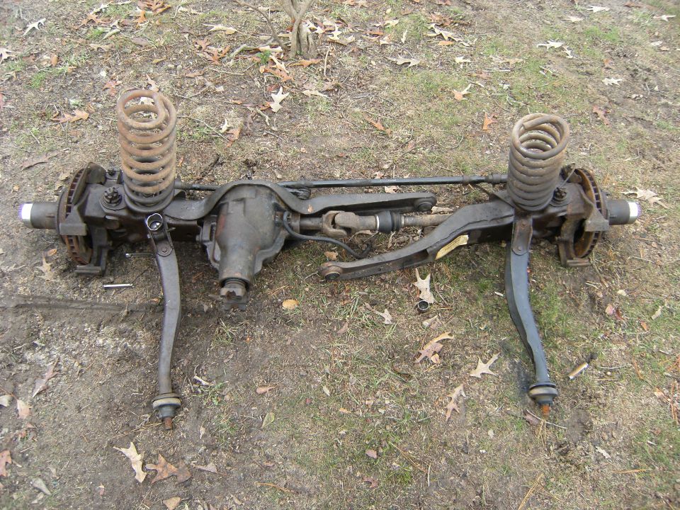 Rear view of removed front axle with coil springs, radius arms and differential