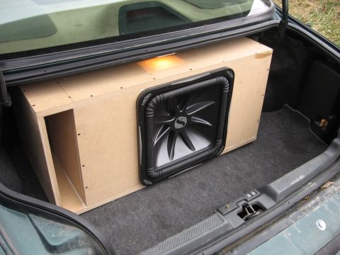 1992 Ford Crown Victoria - The trunk of a green 1992 Ford Crown Victoria contains a custom-built wooden box housing a large Kicker subwoofer.
