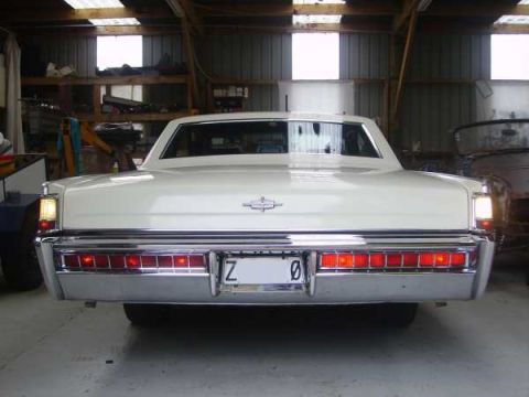 1969 Lincoln Continental - Rear view of a 1969 Lincoln Continental, showing its distinctive taillights and chrome bumper.
