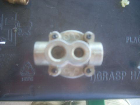 1992 Ford Bronco - A brass fuel flow meter is shown against a dark background with some text and markings.