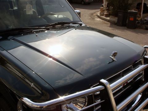 2000 Mitsubishi Montero - A dark green SUV, likely from the 1990s, is shown from the front with a prominent chrome grille and bull bar.