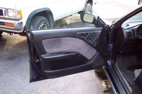 2001 Ford Crown Victoria - Interior door panel and dashboard of a car, with a white pickup truck partially visible outside.