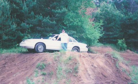 1996 Ford Crown Victoria - 1996 Ford Crown Victoria on a dirt hill with trees in the background.