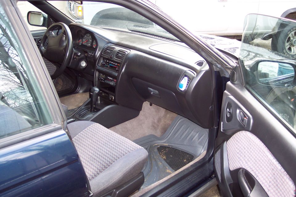 Interior view of a dark blue car's dashboard and front seats