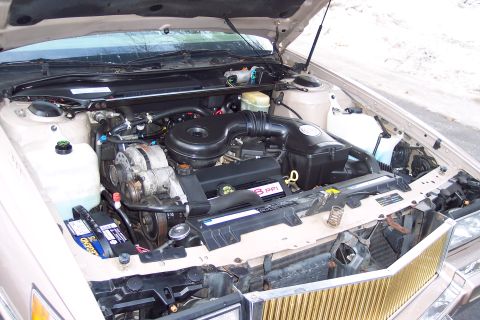 2001 Ford Crown Victoria - The engine bay of a 1993 Cadillac Sixty Special is visible, with the hood open.