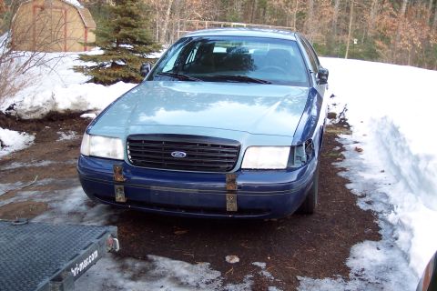 2001 Ford Crown Victoria - A blue and light blue 2001 Ford Crown Victoria is parked outside in a snowy environment.