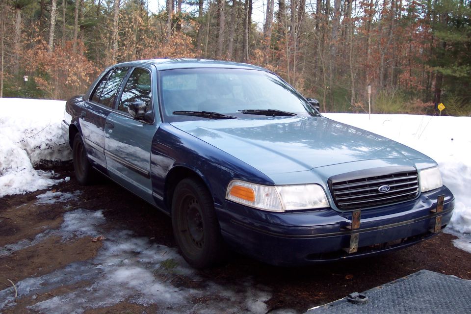 Two-tone blue sedan, front right fender and hood are a lighter shade. Snow on the ground
