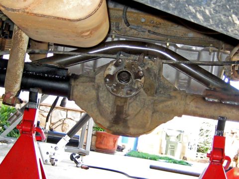 1996 Ford Bronco - Vehicle's rear axle and exhaust components are visible, supported by red jack stands.
