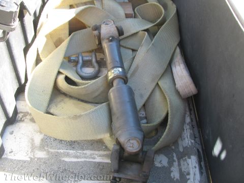 1987 Suzuki Samurai - A driveshaft and tie-down straps are stored in the back of a vehicle.
