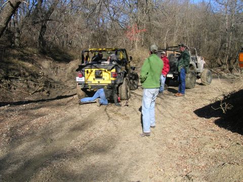 1996 Ford Bronco - Off-roading group works on a Jeep Wrangler stuck in the dirt.