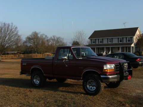 1992 Ford F-150 - Maroon 1992 Ford F-150 pickup truck with a bull bar and 4x4 badging.