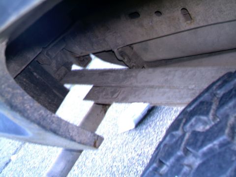 1987 Ford Bronco II - Close-up view of a vehicle's undercarriage, showing structural components and a tire.