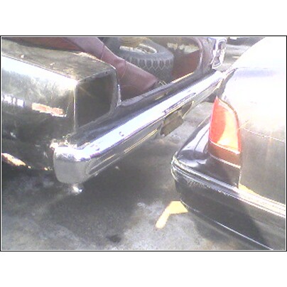 1972 Ford Ranchero - Two cars are parked side-by-side, focusing on their rear bumpers and trunk areas.