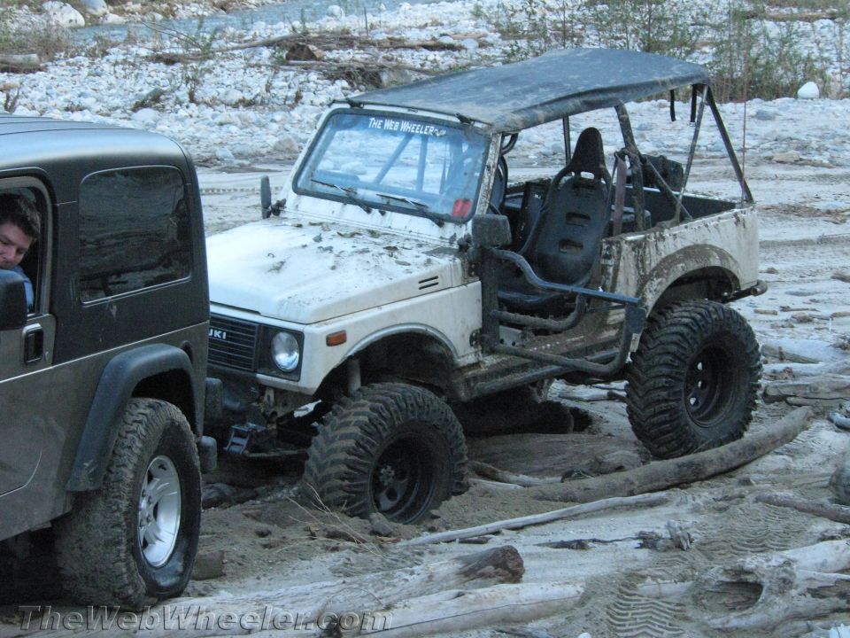 White 1987 Suzuki Samurai off-roading with another vehicle