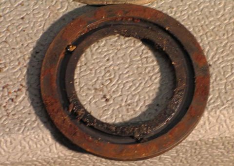 1994 Ford Bronco - This close-up shows a heavily rusted metal ring with a worn rubber seal, likely a vehicle part.