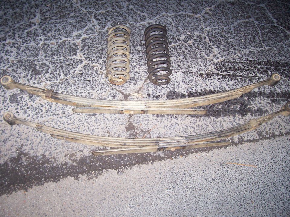 Two leaf springs and two coil springs on asphalt