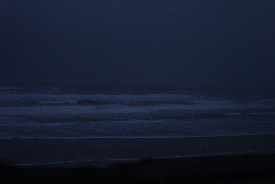 Ocean waves rolling onto a dark beach at dusk. Text overlay reads SUPERMOTORS
