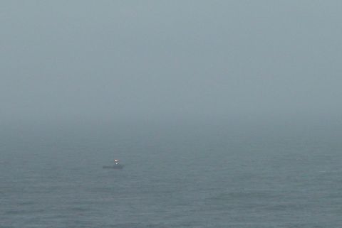 1993 Ford Bronco - A small boat with lights is visible on the water in a foggy scene.