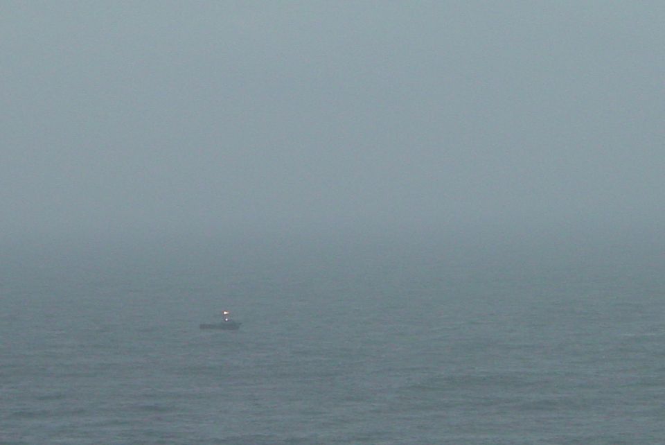 Boat with lights on the water in fog