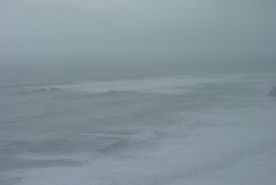 Ocean waves crashing under a foggy sky. Supermotors.net logo in the corner