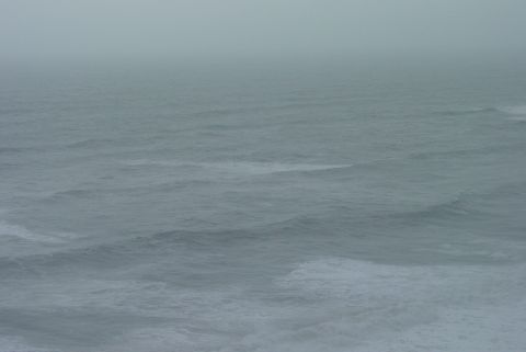 1993 Ford Bronco - The vast ocean stretches out under a hazy sky, with waves gently rolling across the surface.